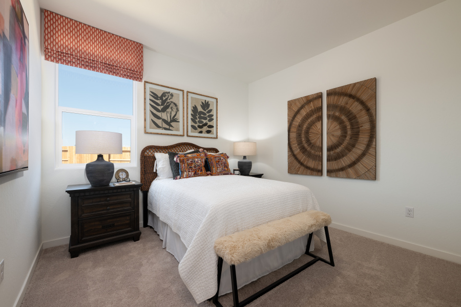 A bedroom with a bed and lamps.