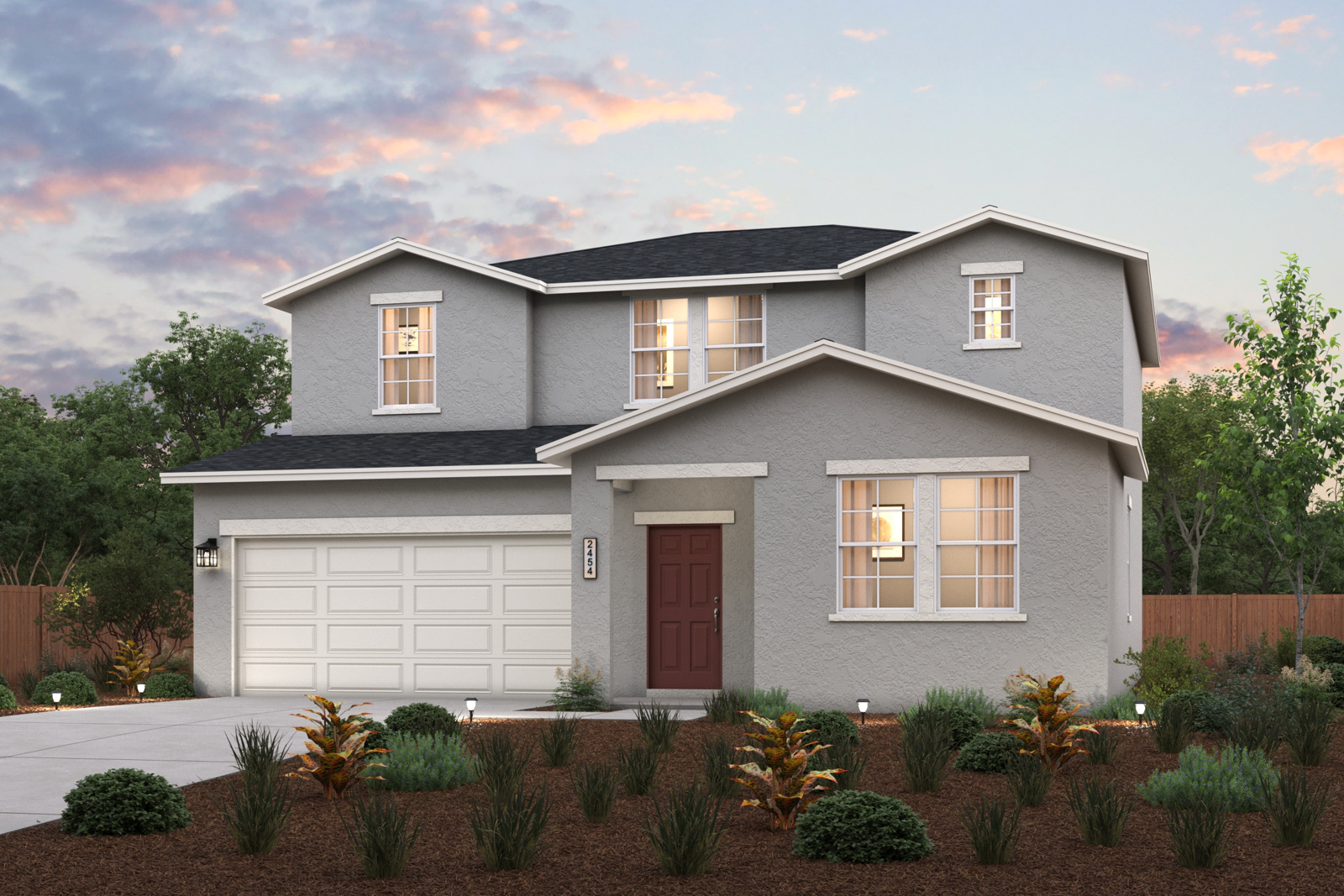 A house with a garage and bushes in front of it.