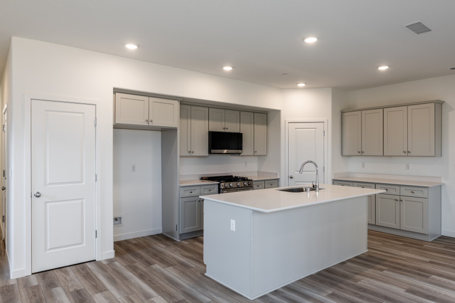 A kitchen with white cabinets.