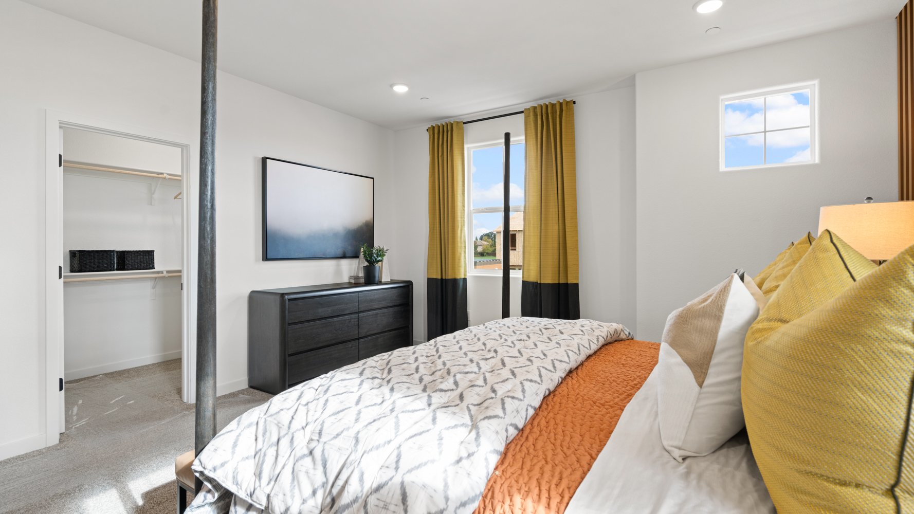 A bedroom with a bed and a dresser.