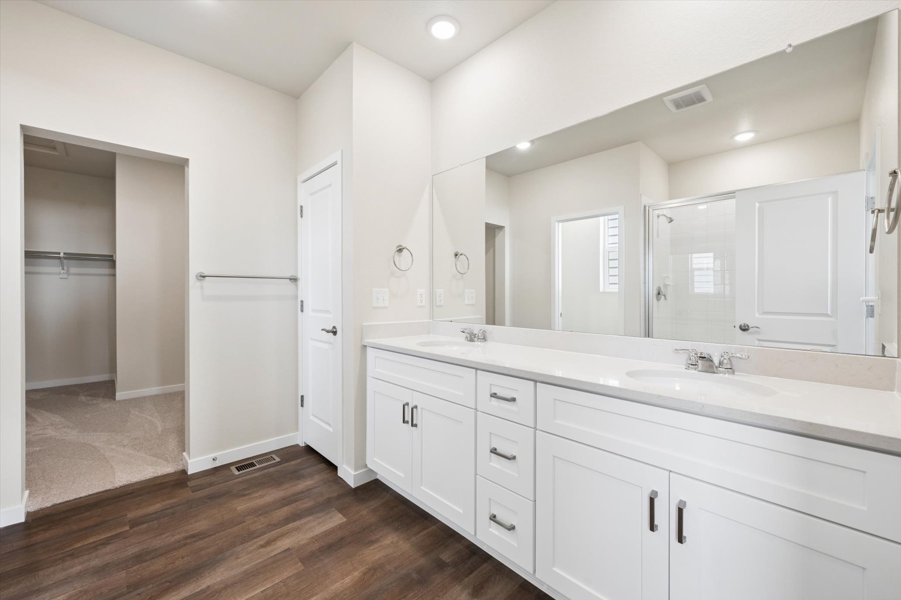 A bathroom with white cabinets.