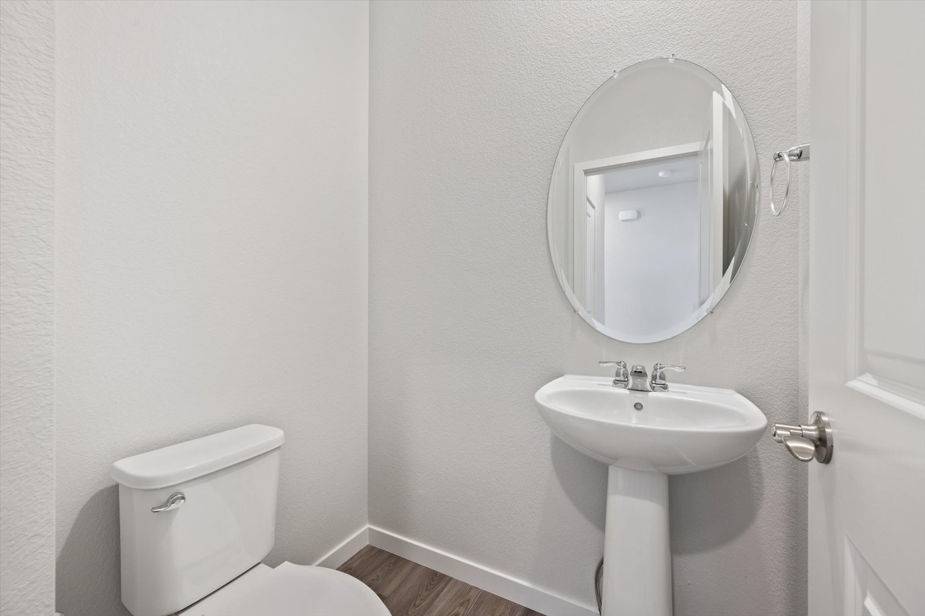 A bathroom with a round mirror.