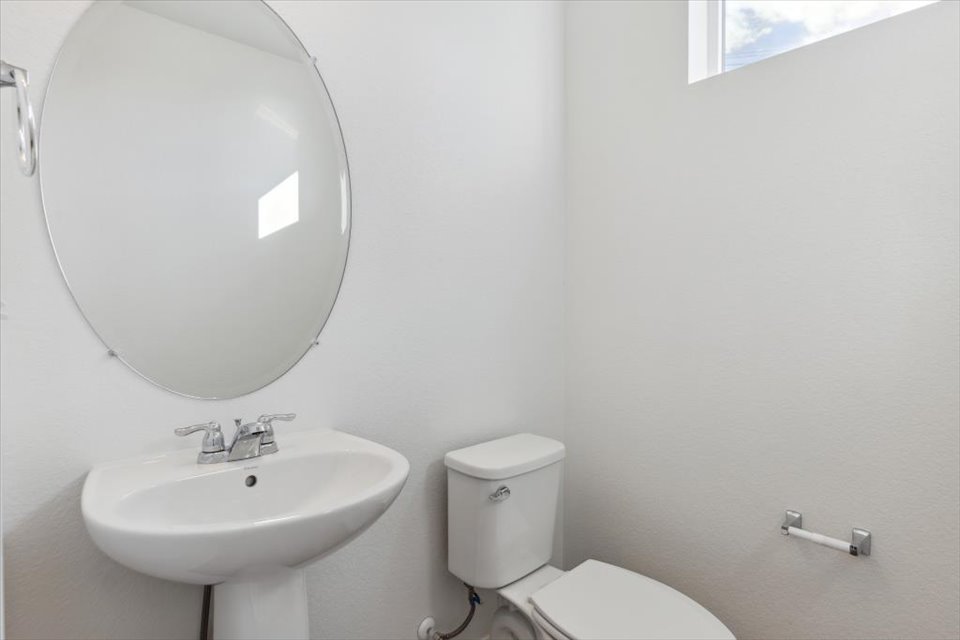A bathroom with a round mirror.