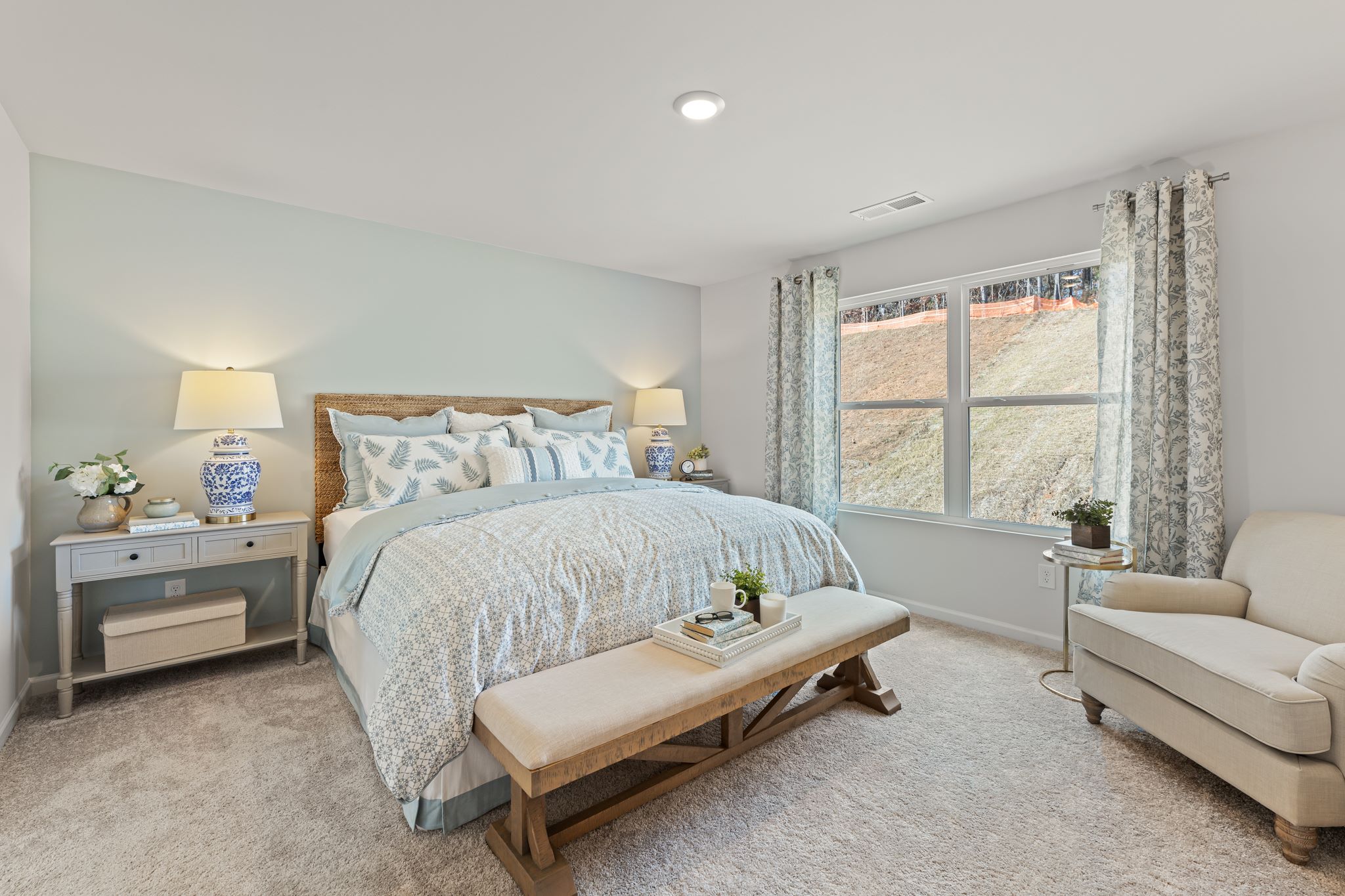 A bedroom with a bed and a bench.