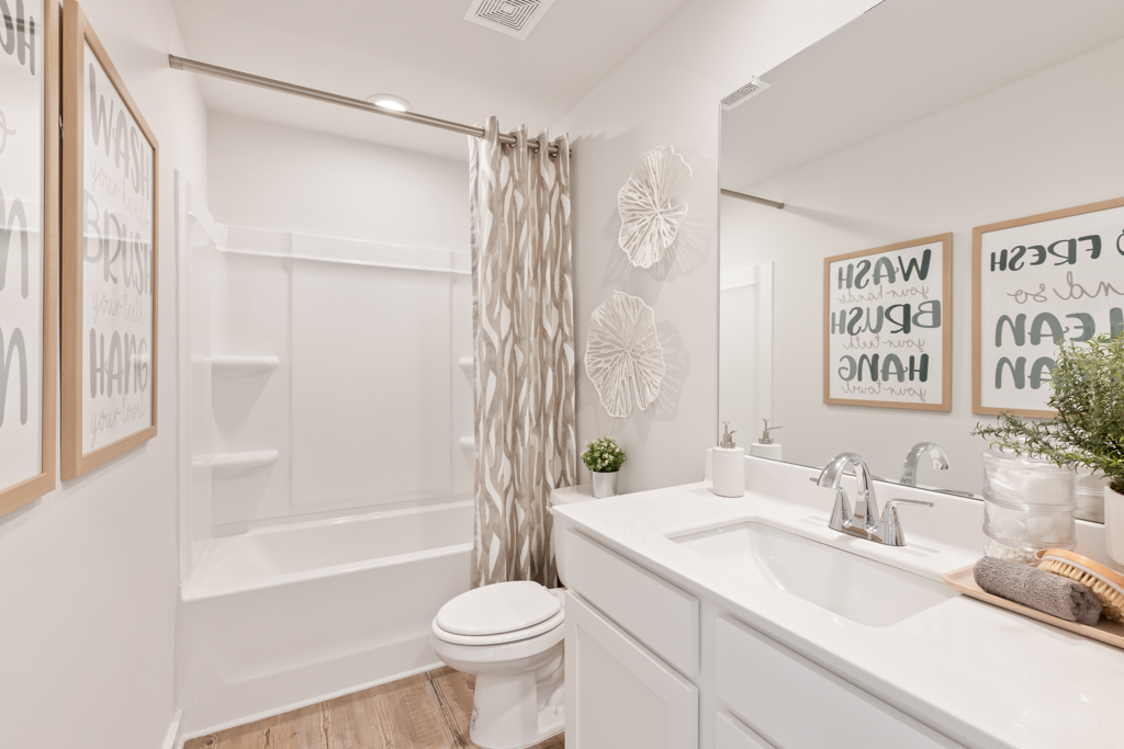 A bathroom with a tub sink and toilet.