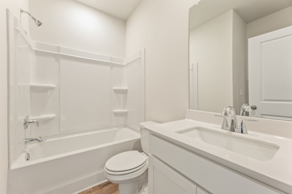 A bathroom with a tub sink and toilet.