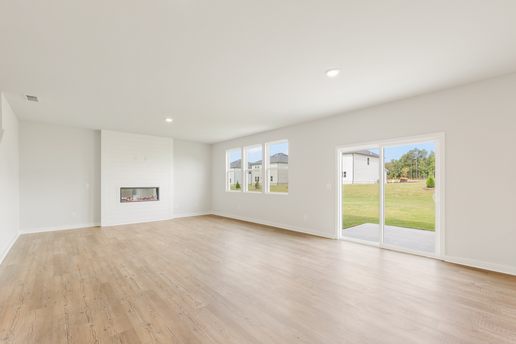 A room with a wood floor and a wood floor with a large window.