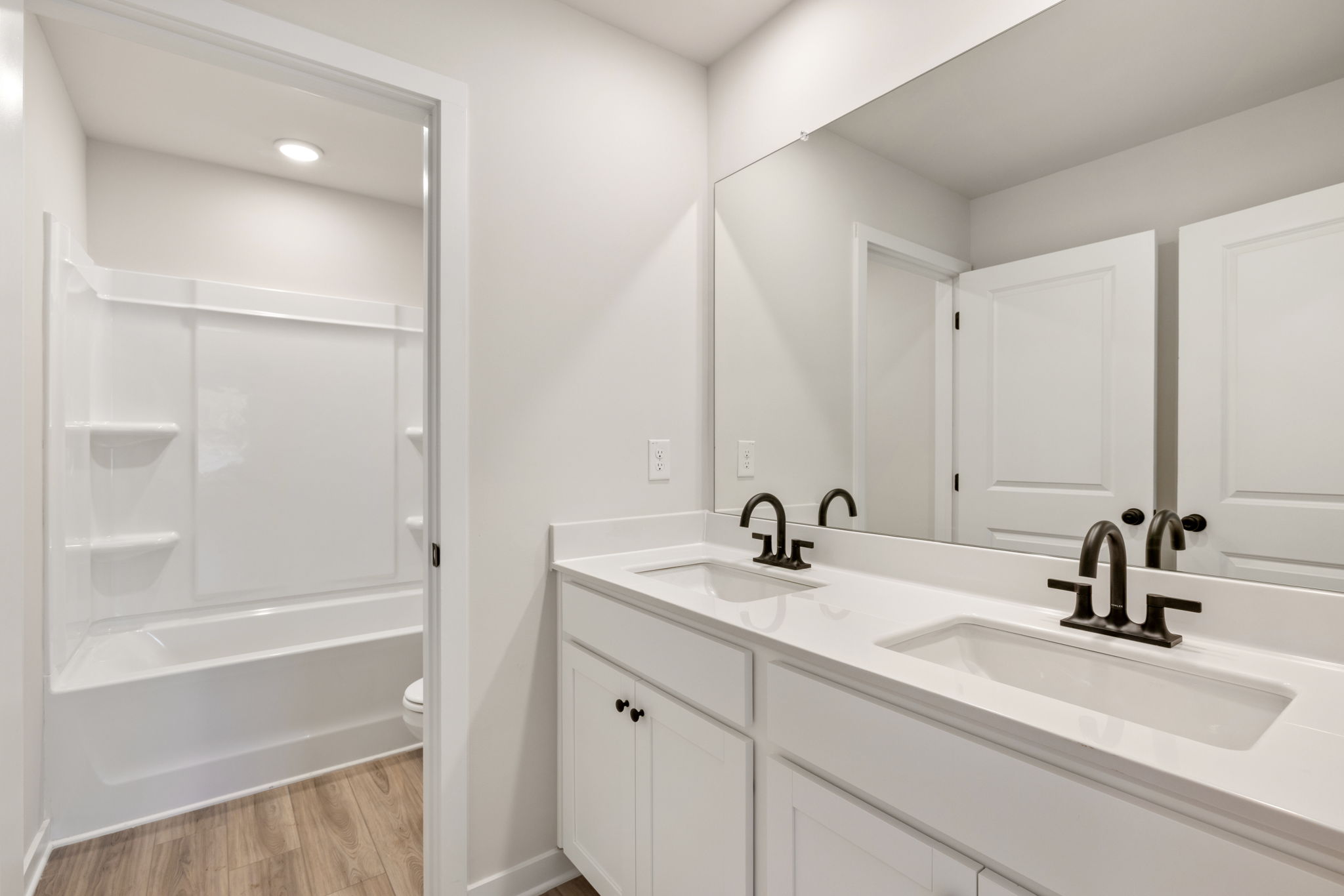 A bathroom with white cabinets.