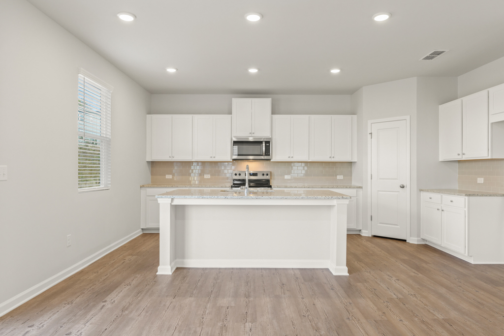 A kitchen with white cabinets.