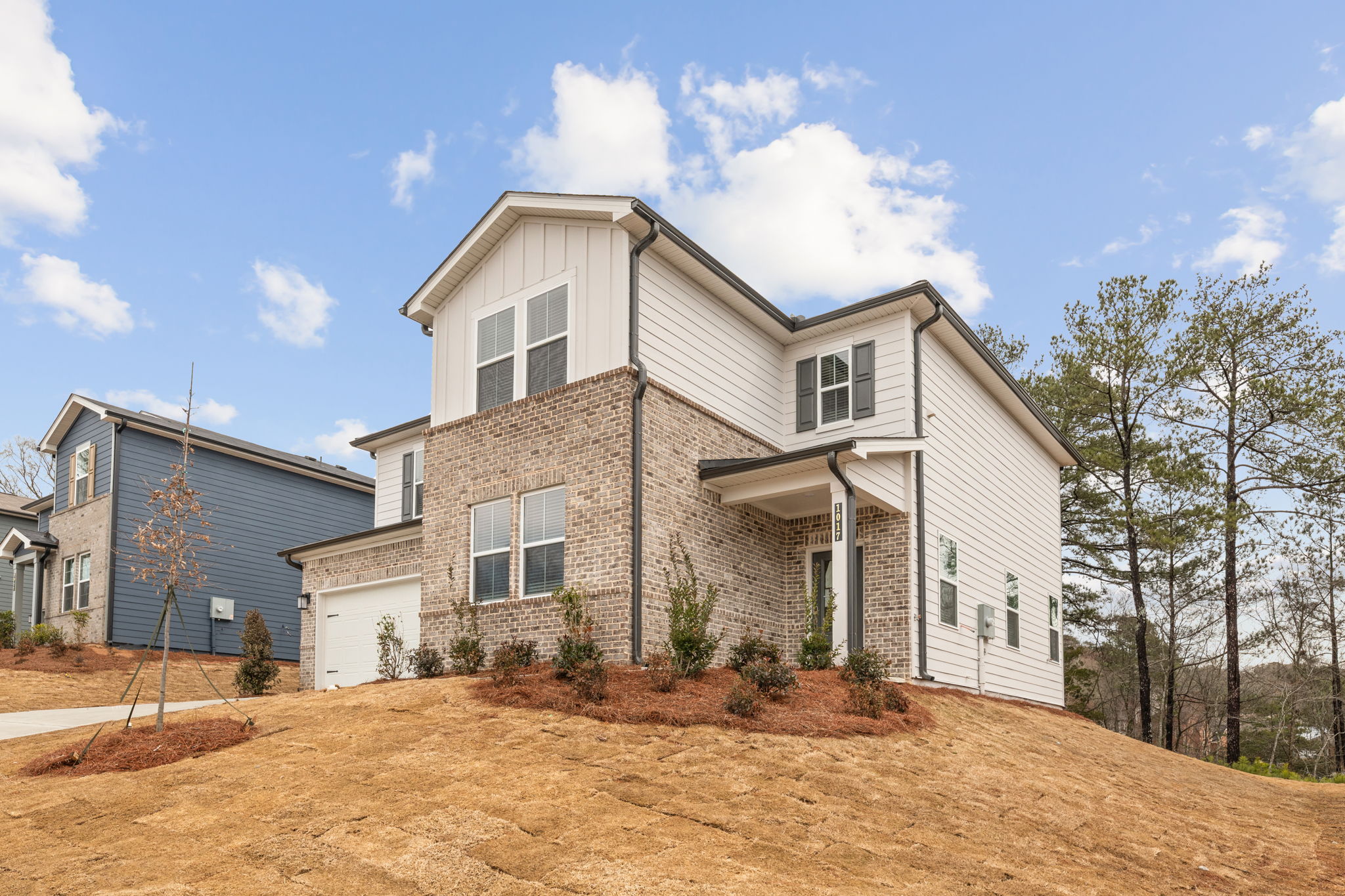 A house with trees and dirt in front of it.