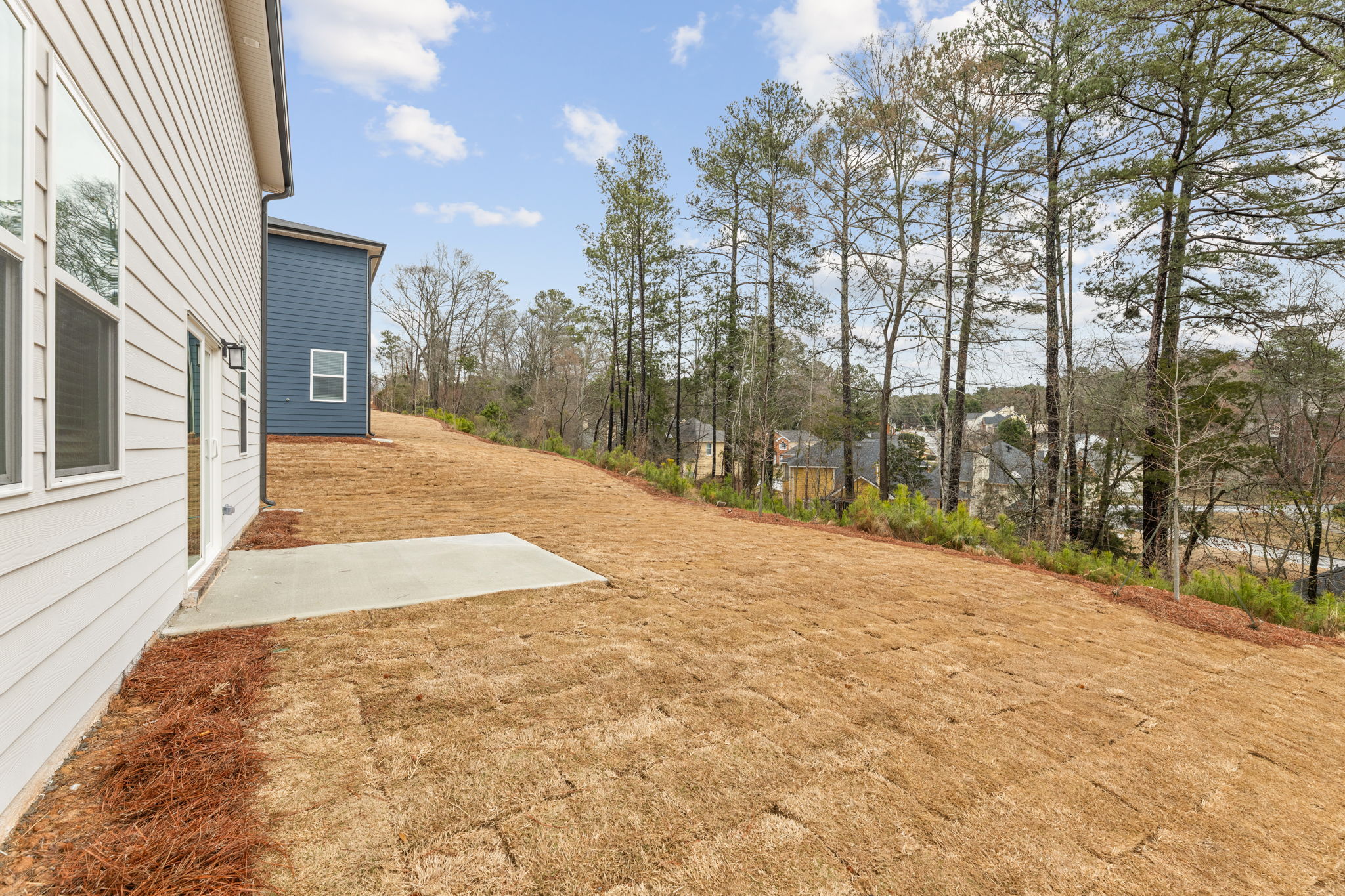 A dirt path next to a house.