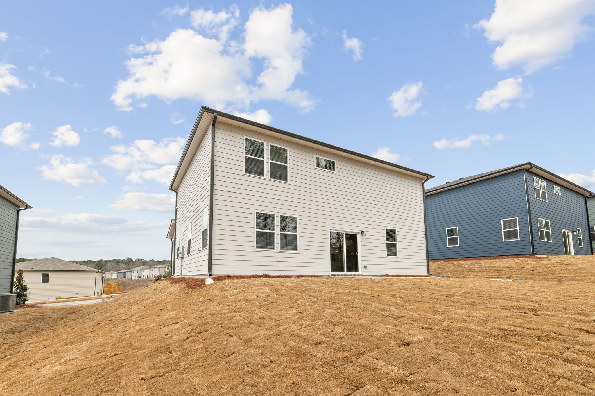A house with a dirt field in front of it.