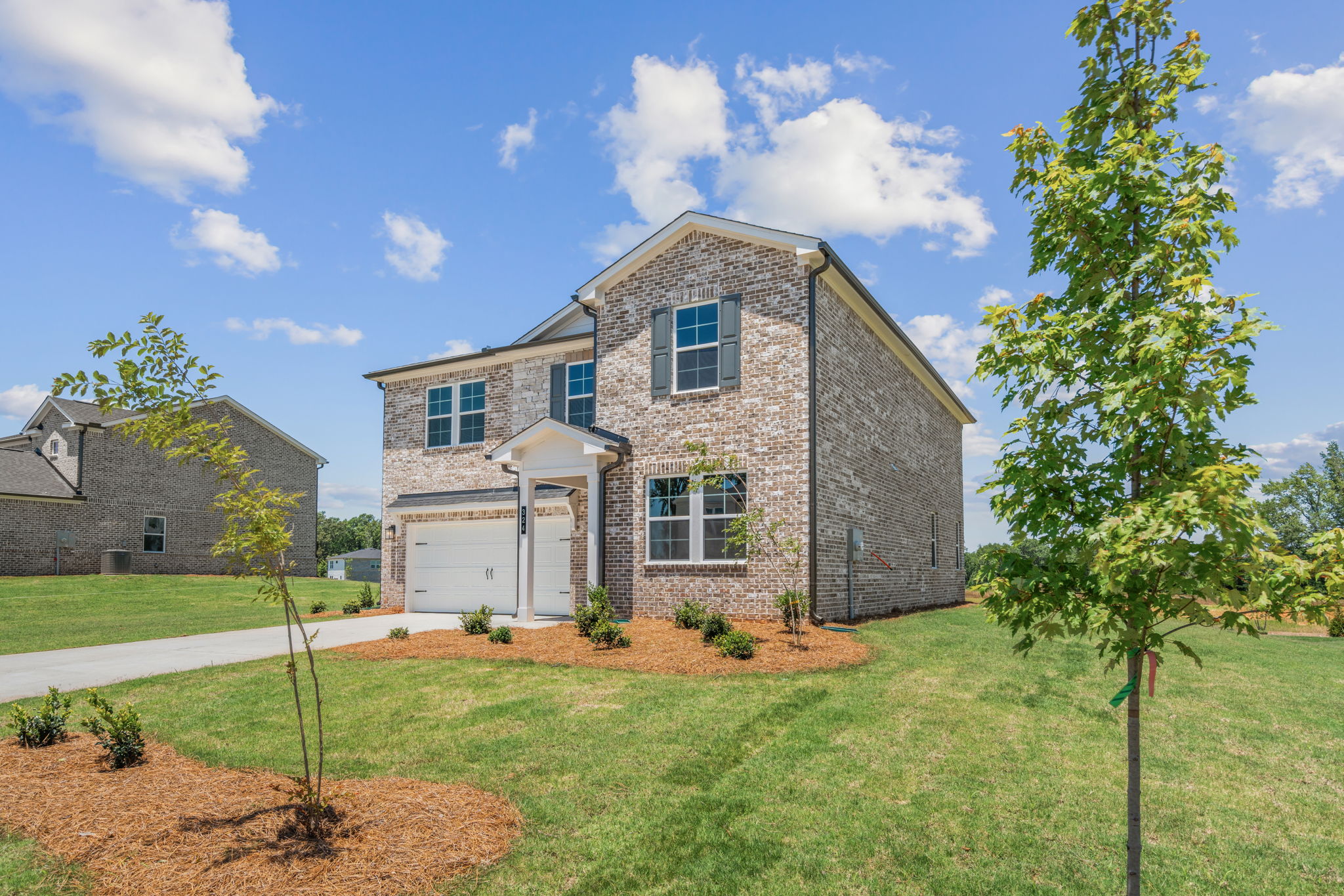 A stone house with a driveway.