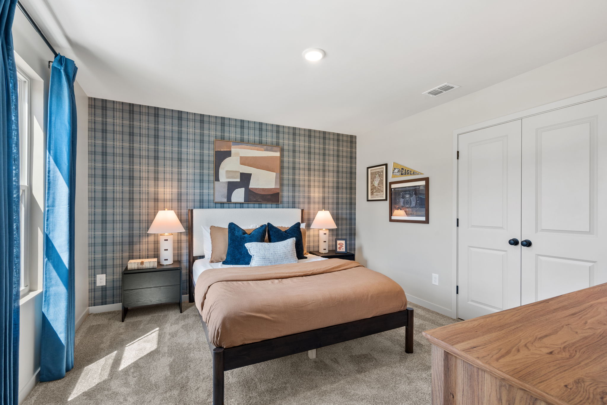 A bedroom with a bed and lamps.