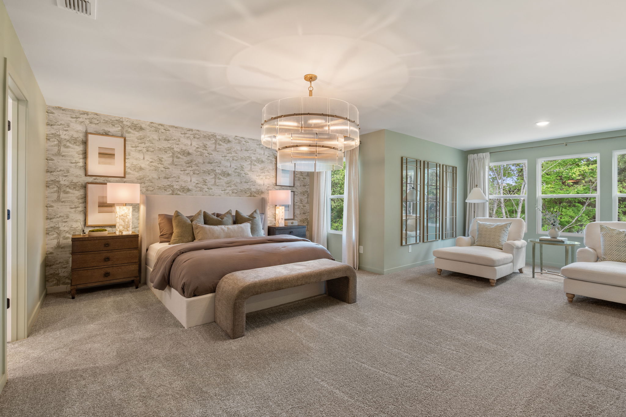 A large bedroom with a bed and a chandelier.