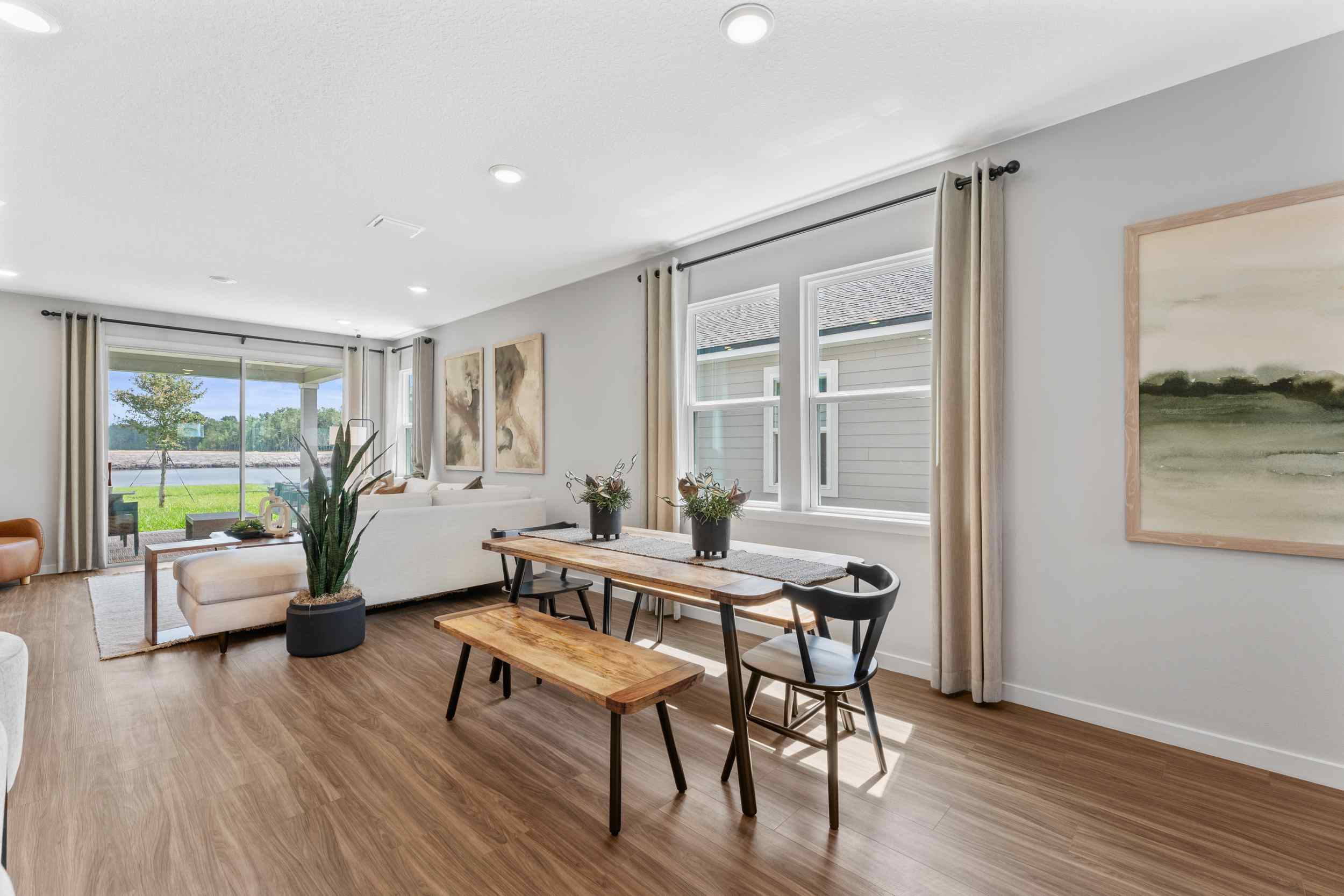 Silverbell II Model Home Dining Area with Table Next to Living Room at Camden Woods in Kingsland, GA