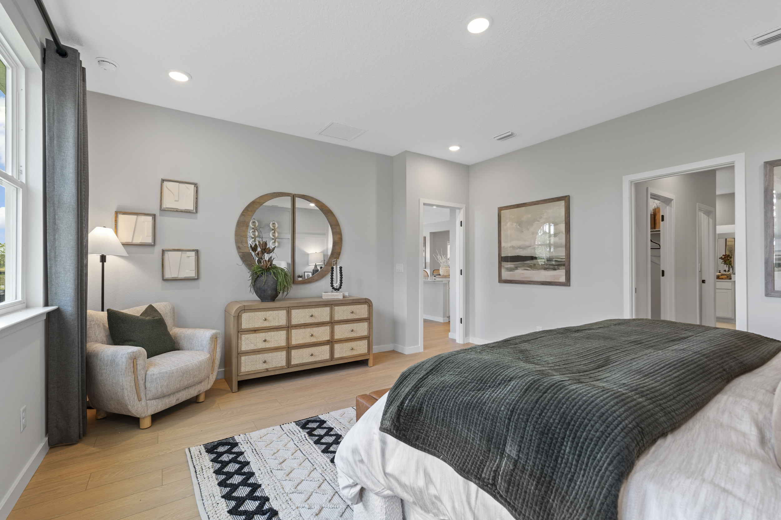 Kenai Model Home Primary Bedroom with Dresser and Chair at Reserve East in Flagler Beach