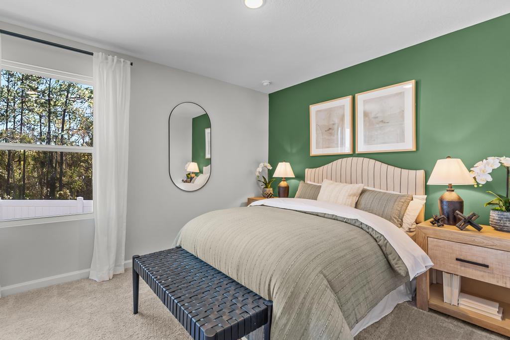 A bedroom with a bed and a mirror.