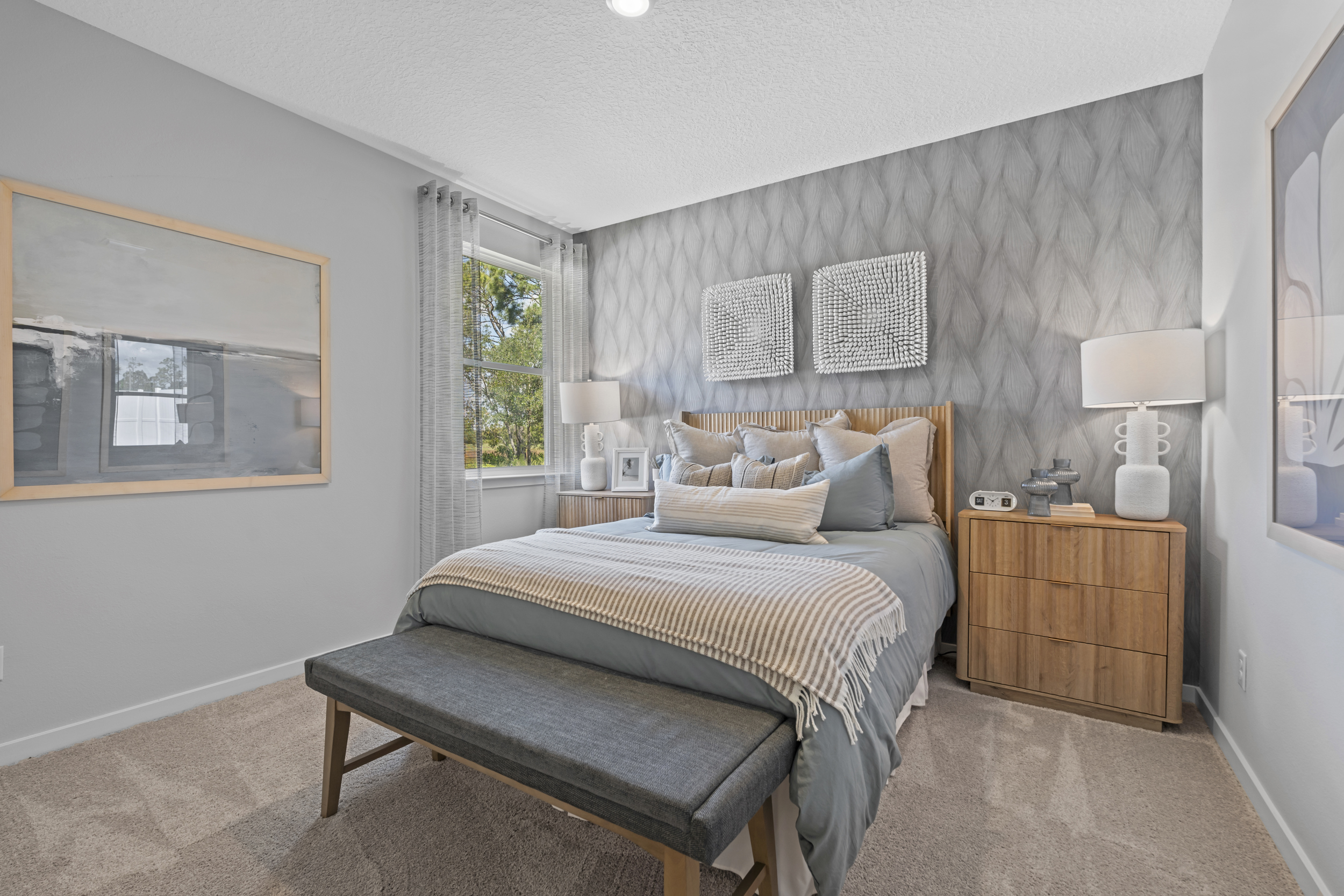 Coronado Model Home Guest Bedroom with Bed and Bench at Reserve East in Flagler Beach