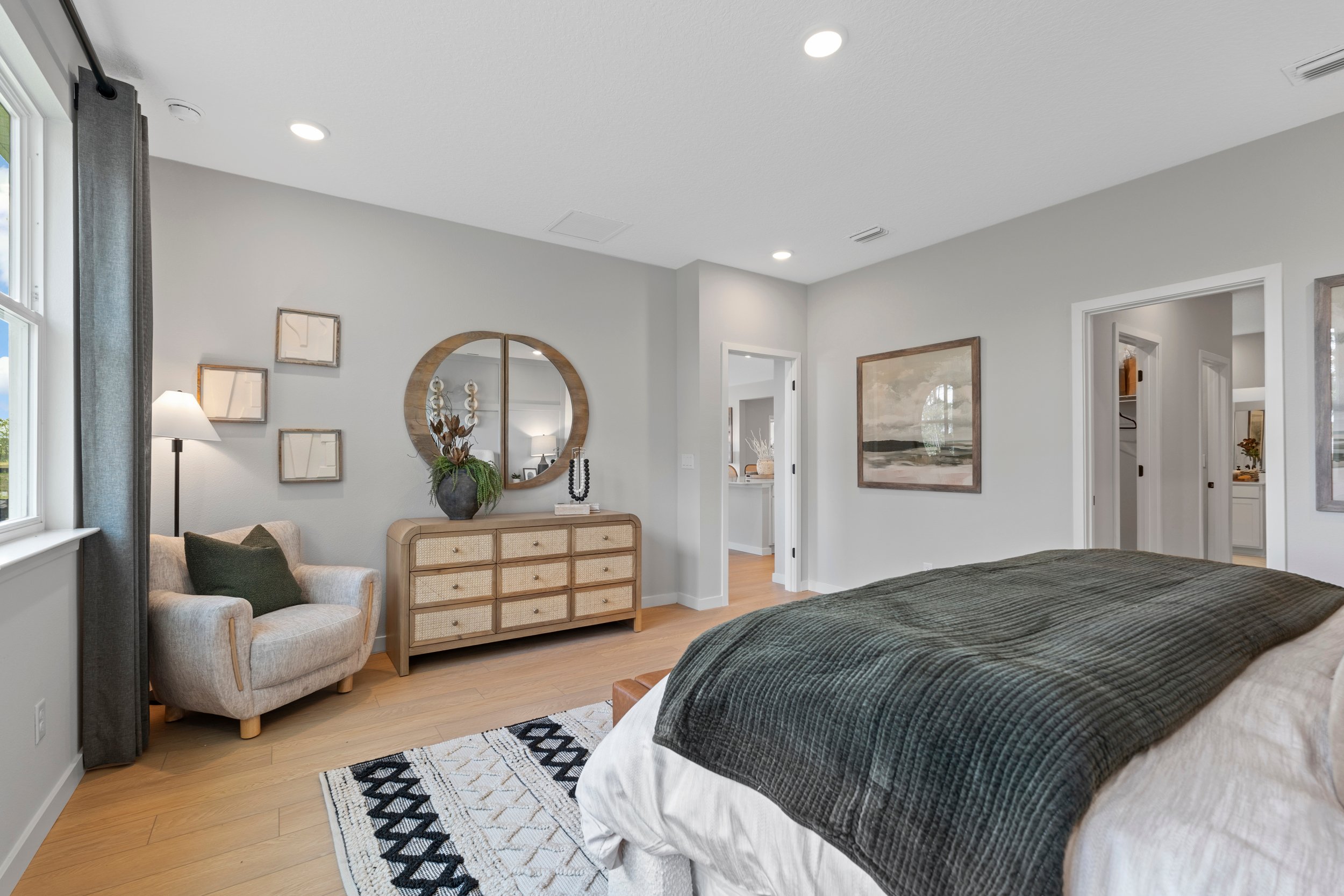 Kenai Model Home Primary Bedroom with Dresser and Chair at Reserve East in Flagler Beach