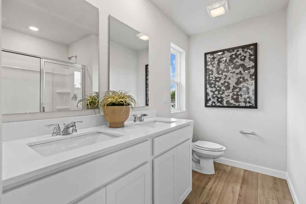A bathroom with a sink toilet and a mirror.