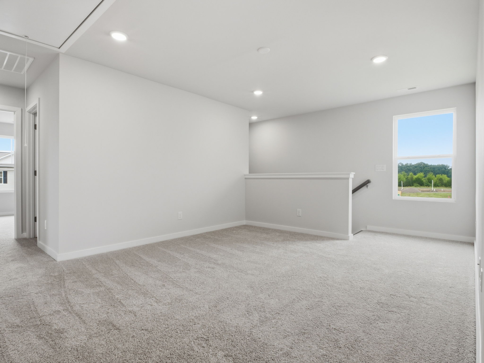 A room with a window and a white wall.