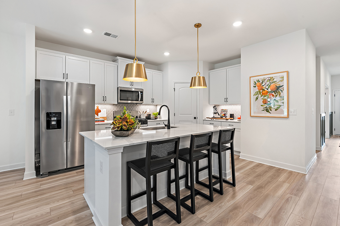 A kitchen with a dining table and a refrigerator.