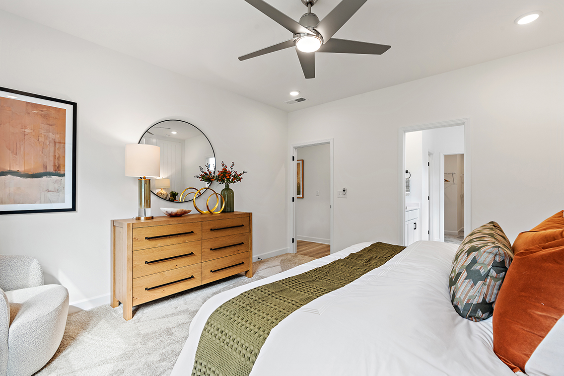 A bedroom with a bed and a fan.