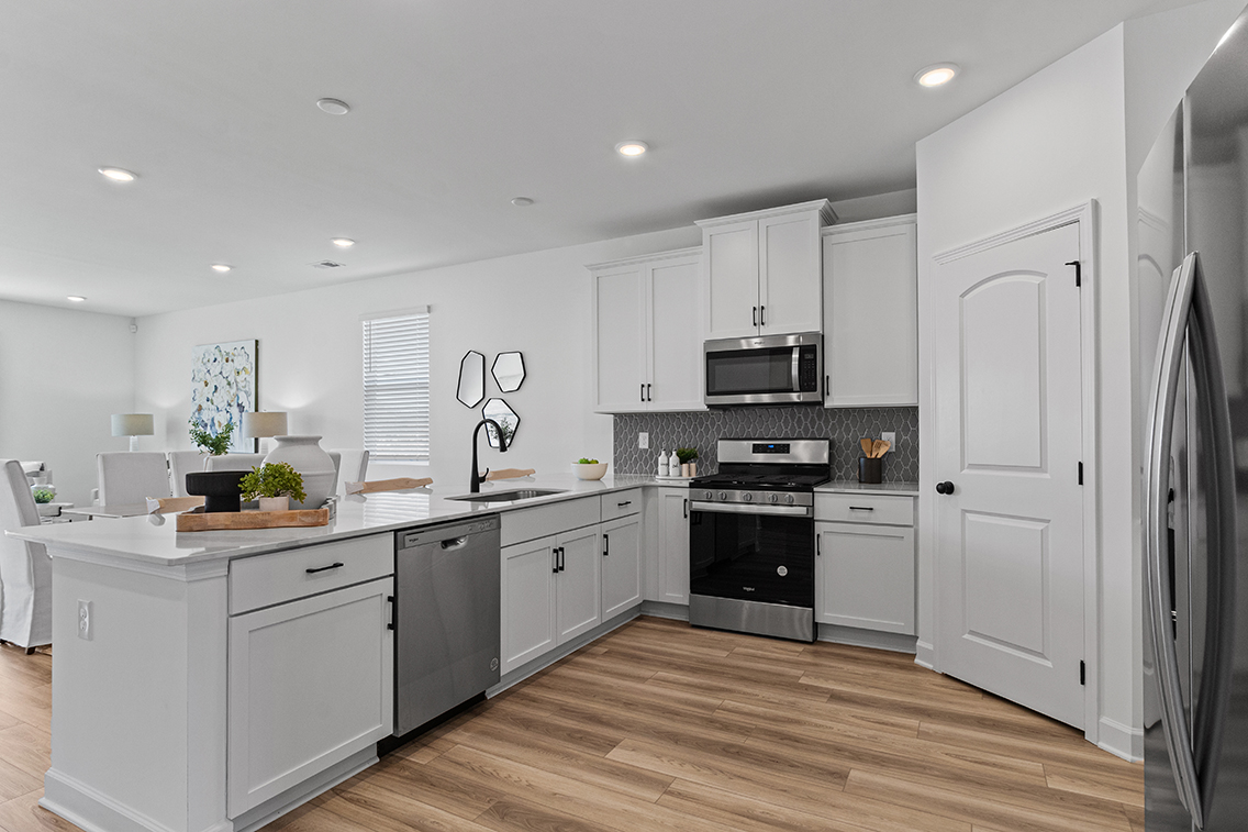A kitchen with white cabinets.