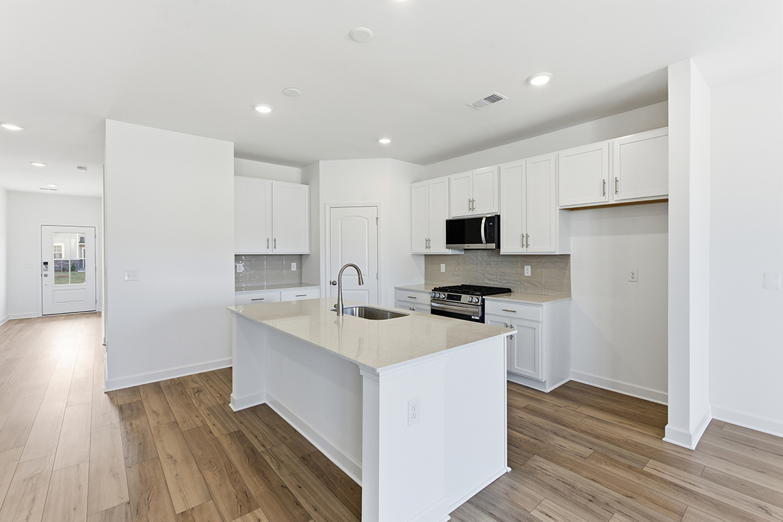A kitchen with white cabinets.
