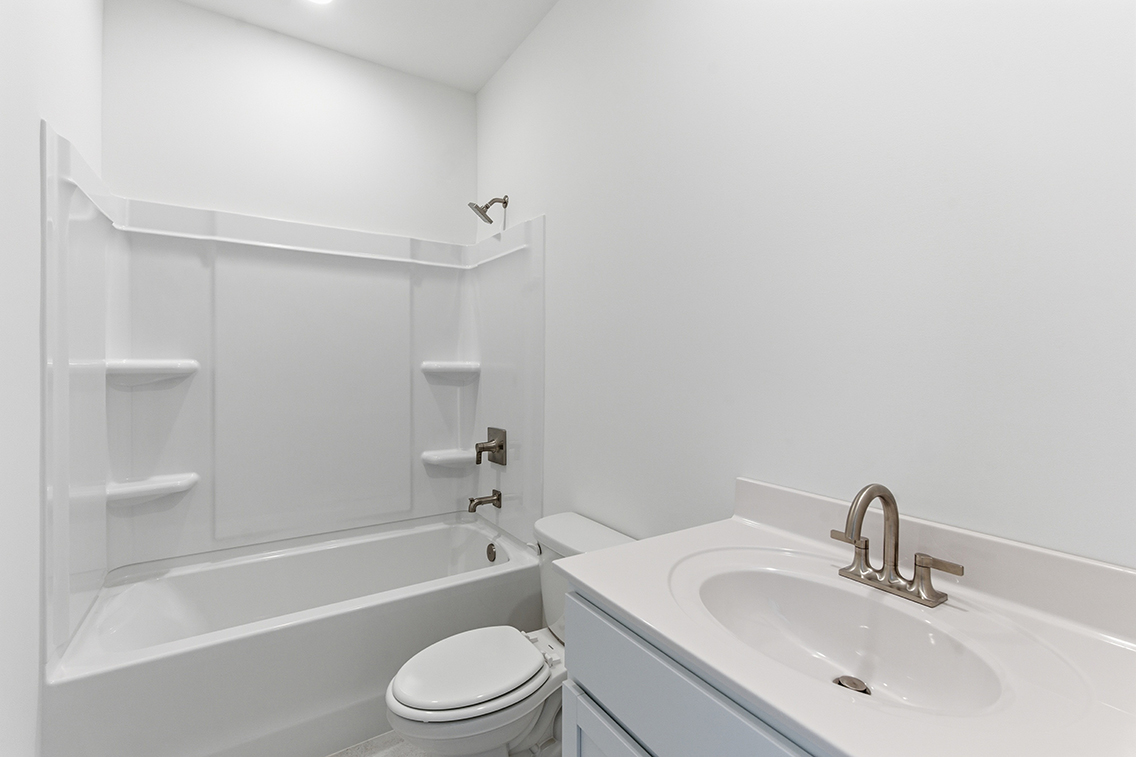 A bathroom with a sink toilet and bathtub.
