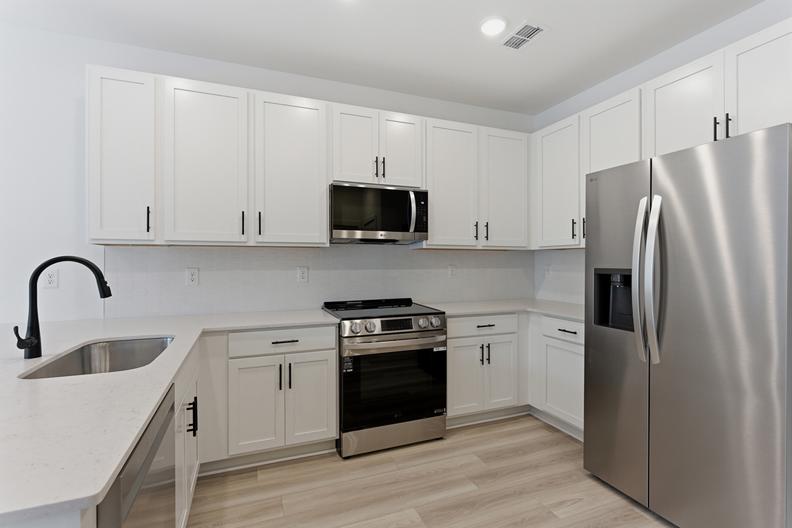 A kitchen with white cabinets.
