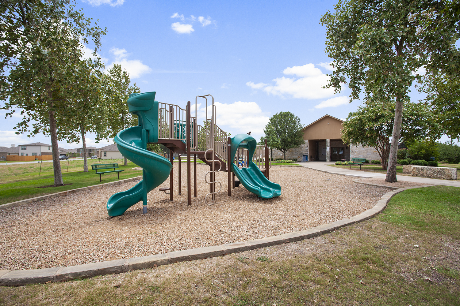 A playground with trees and grass.
