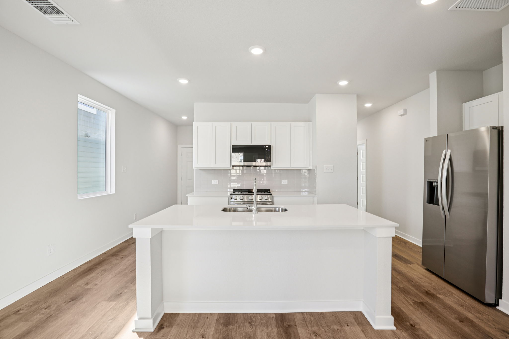 A kitchen with white cabinets.