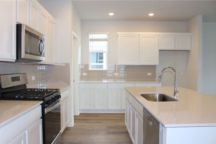 A kitchen with white cabinets.