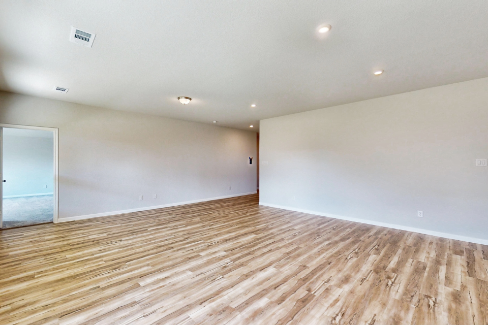 A room with a wood floor and a white wall.