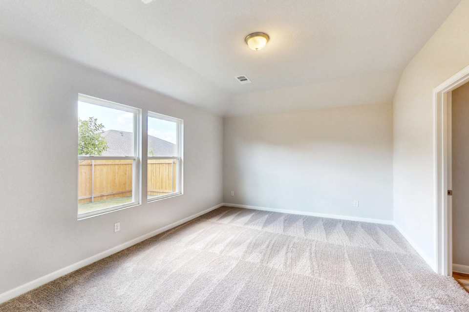 A room with a carpet and windows.