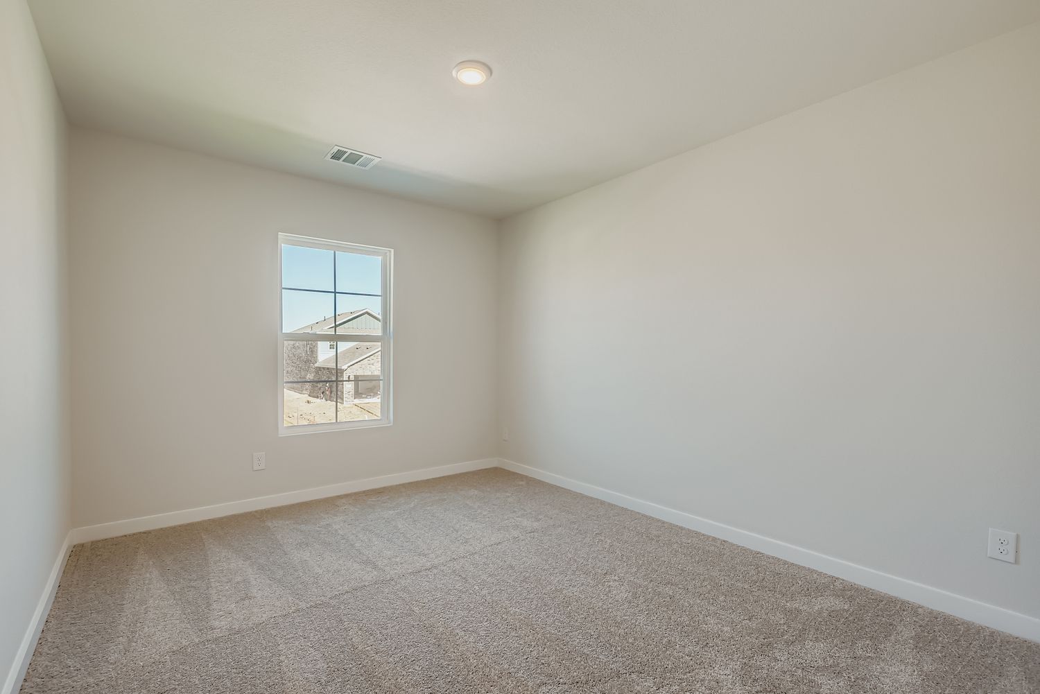 A room with a window and a carpet.