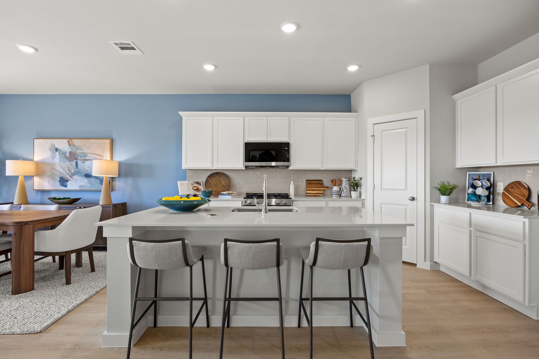 A kitchen with white cabinets.
