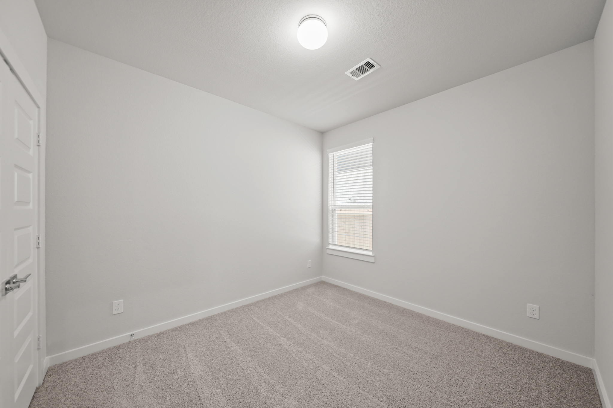 A room with a carpet and a window.