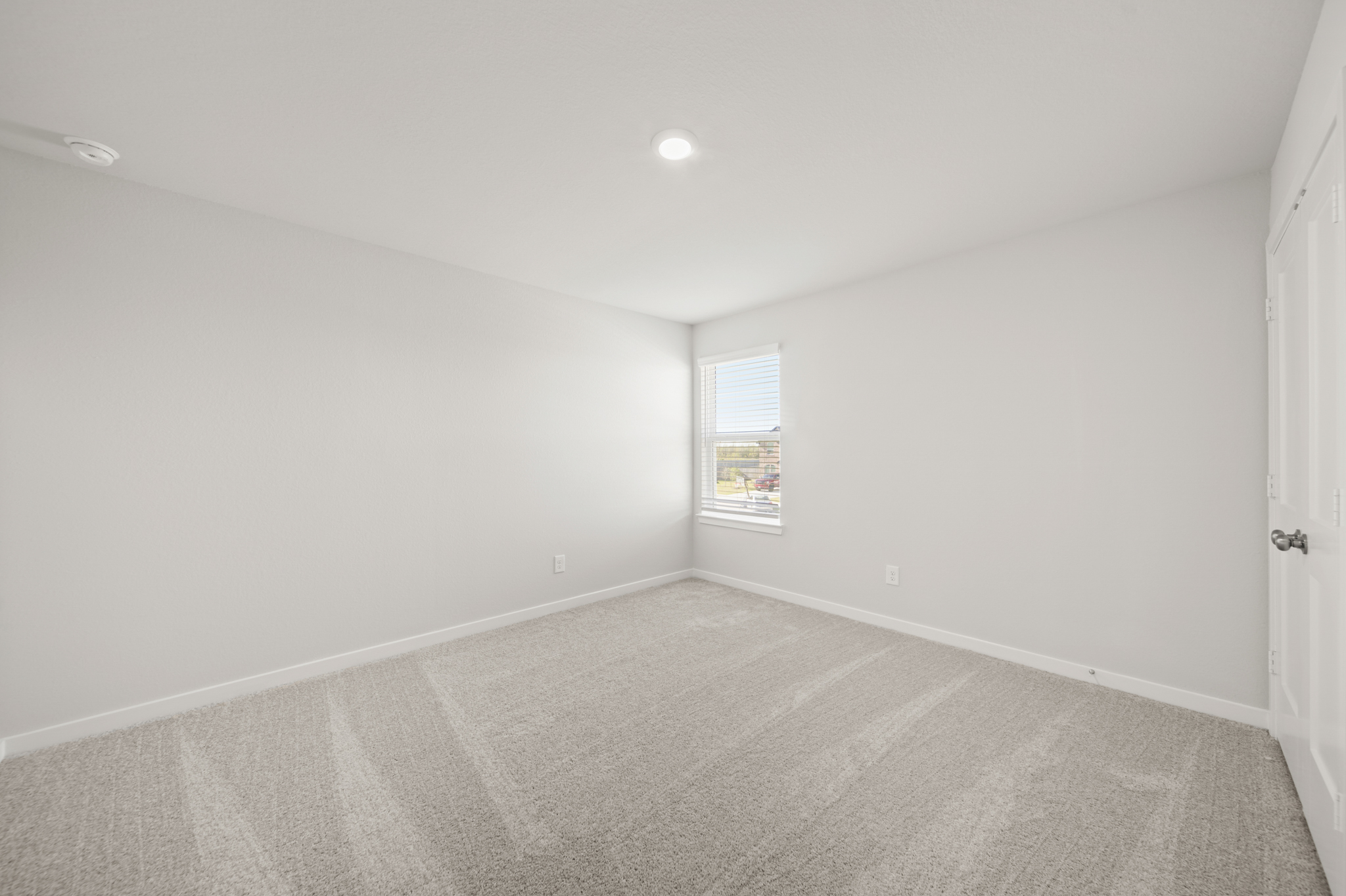 A room with a carpet and a window.