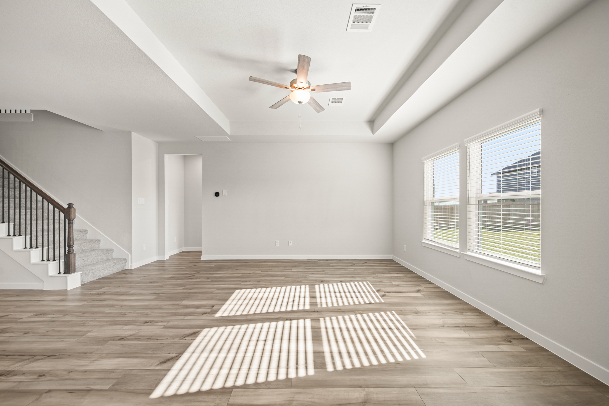 A room with a wood floor and a ceiling fan.