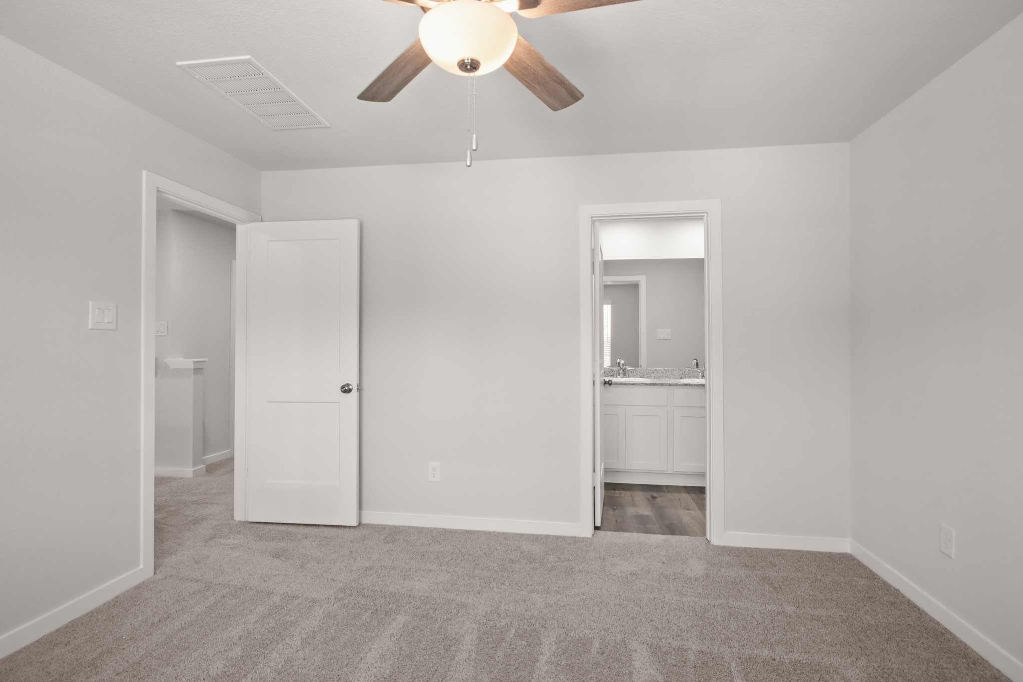 A room with white walls and a ceiling fan.