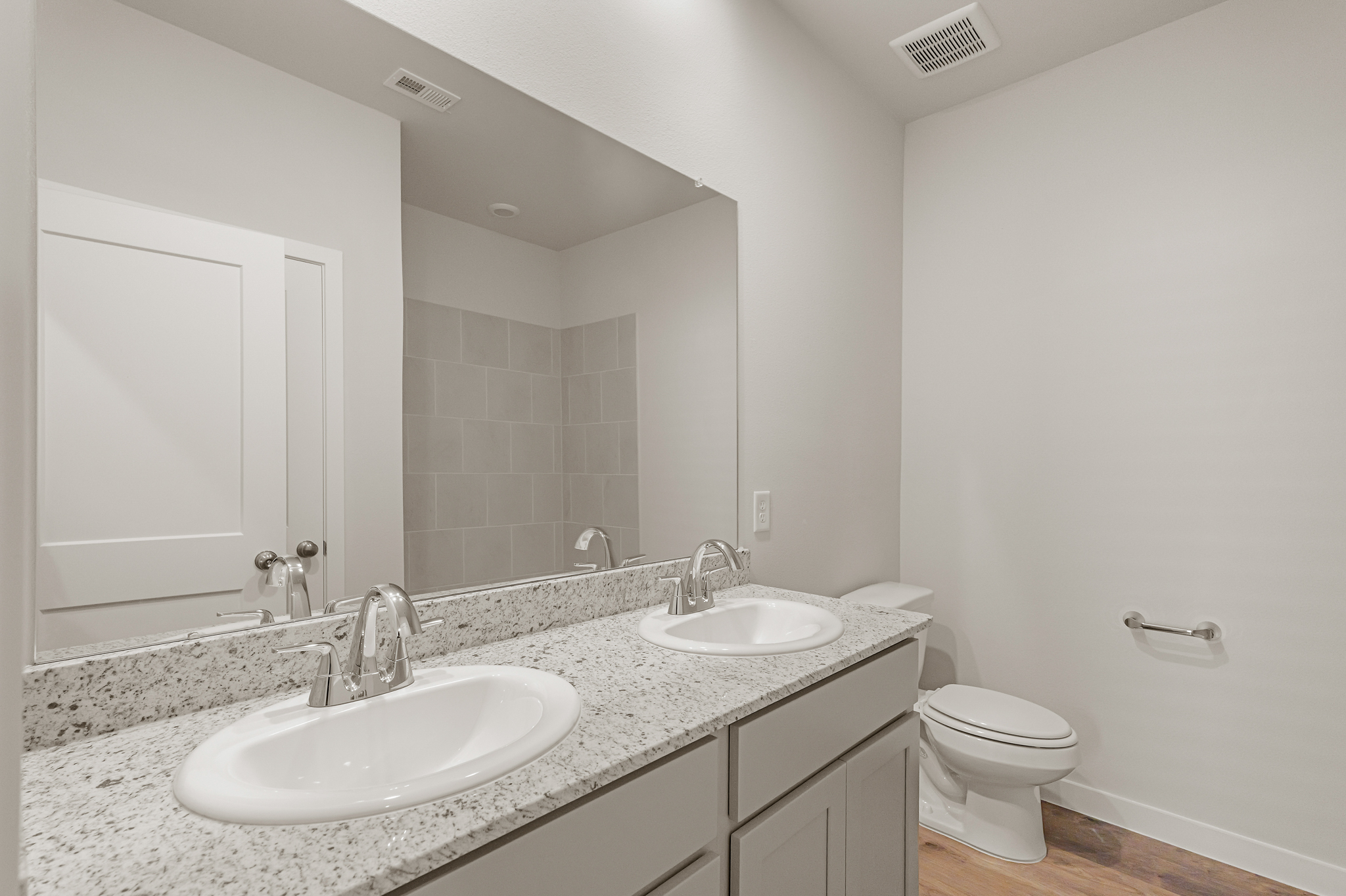 A bathroom with a large mirror.