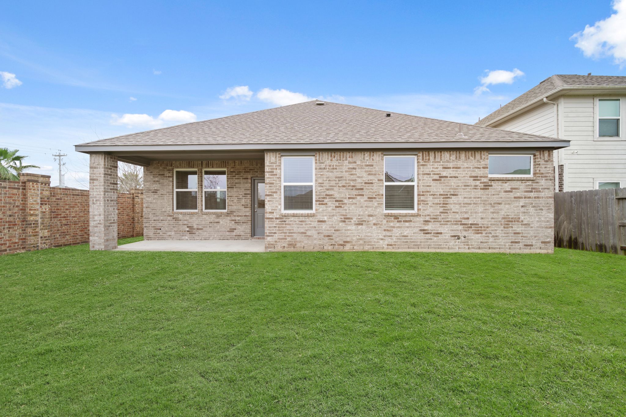 A brick house with a grass yard.