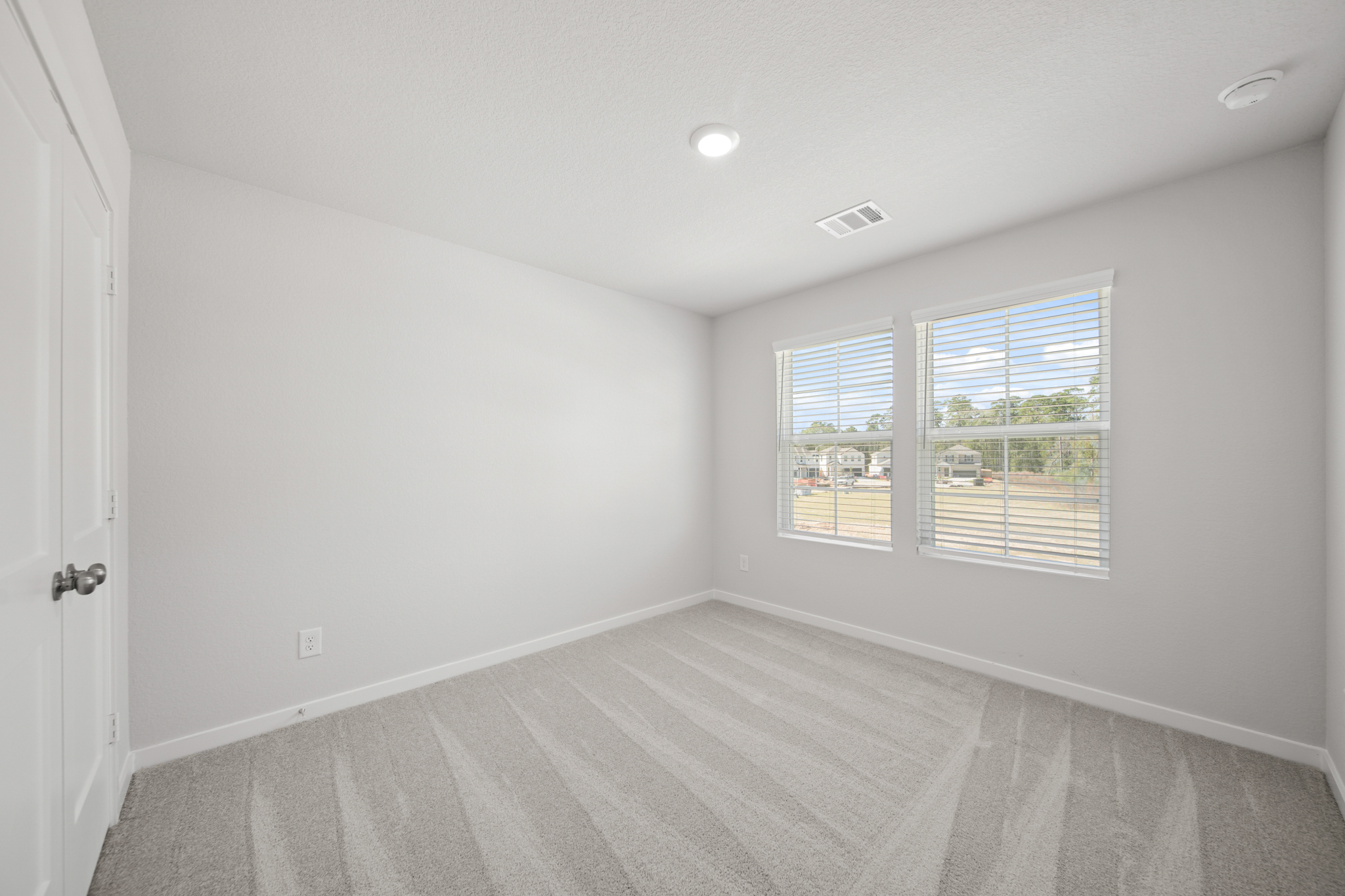 A room with a wood floor and windows.