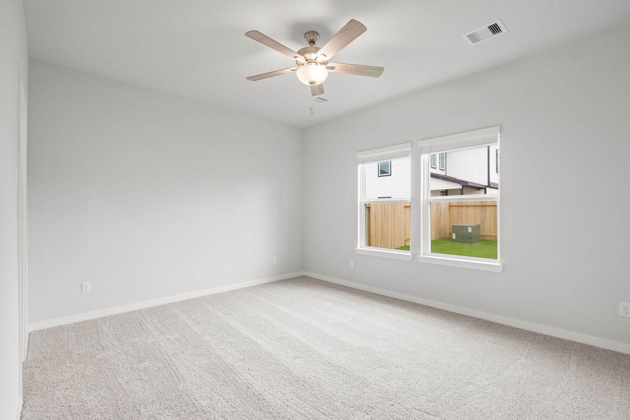 A room with a ceiling fan and a window.