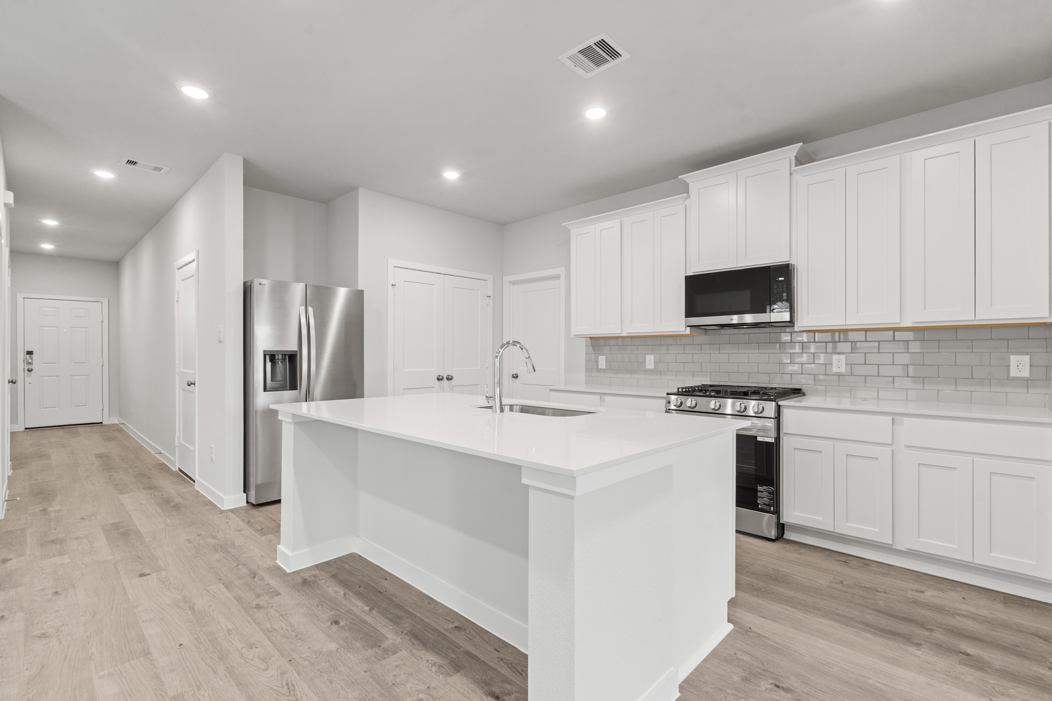 A kitchen with white cabinets.
