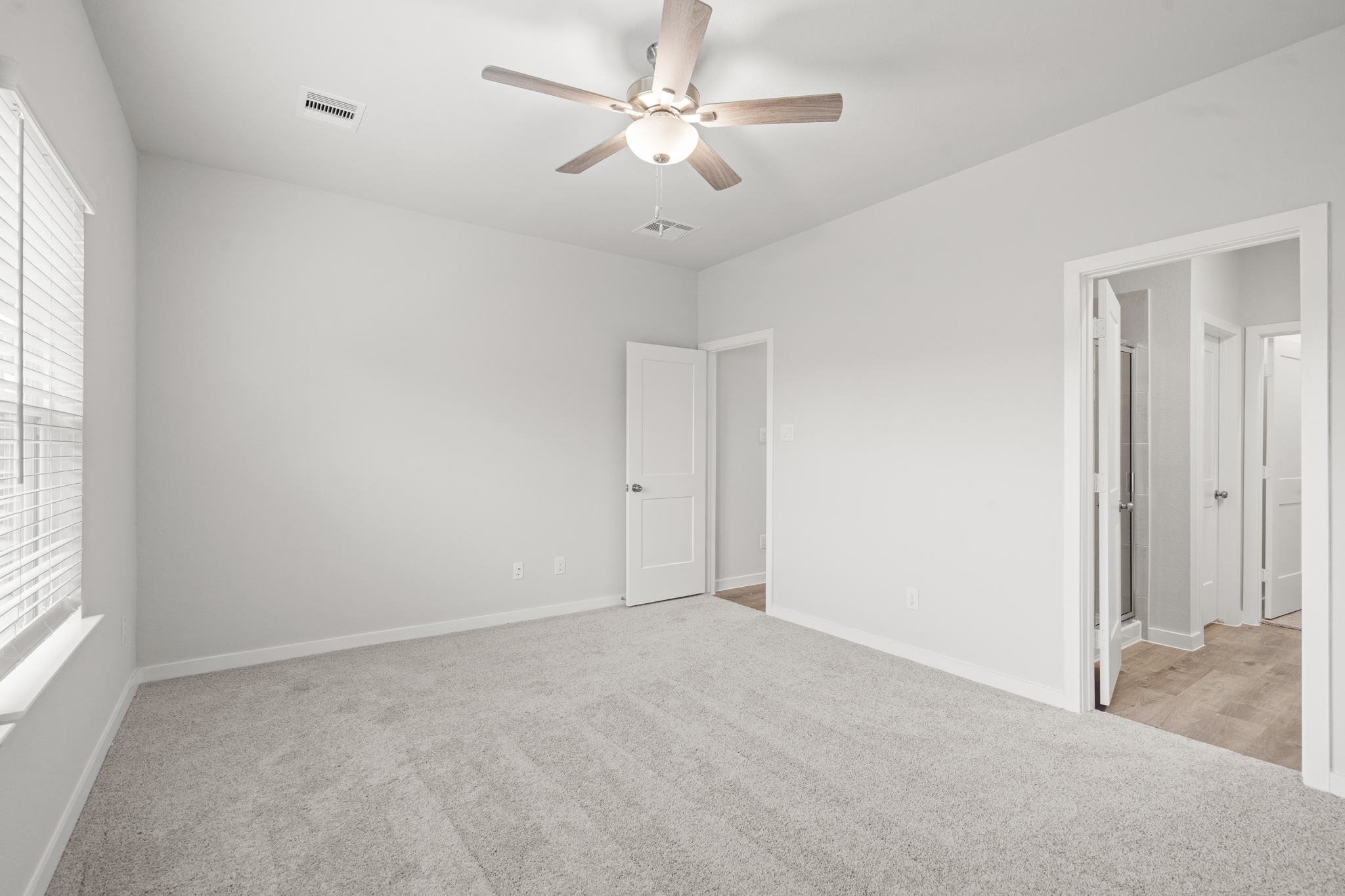 A room with white walls and a ceiling fan.