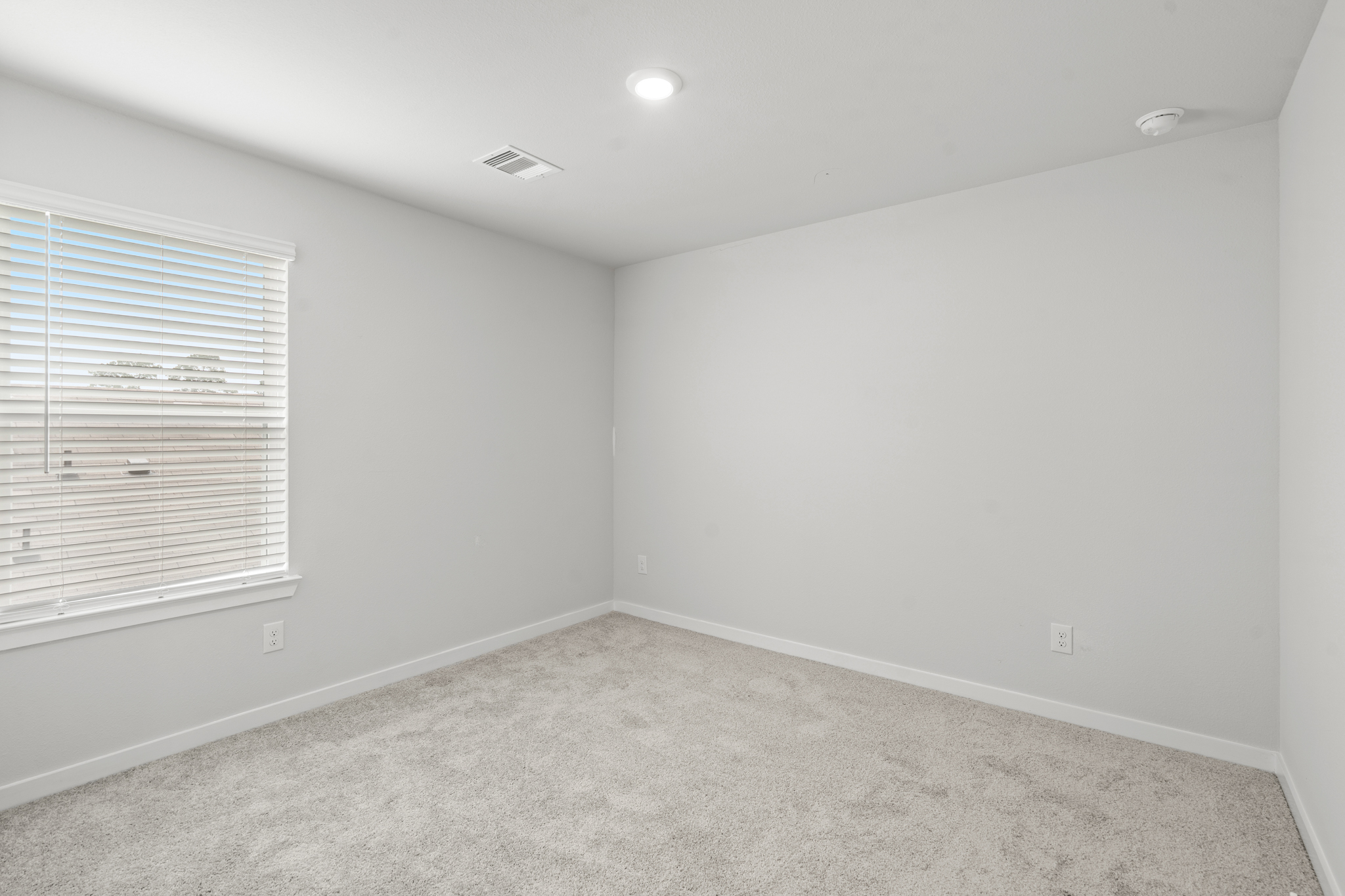 A room with a window and a carpet.